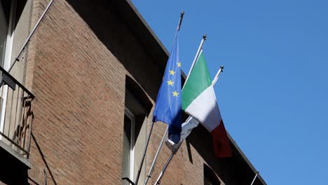 Banderas-De-La-Unión-Europea-E-Italia-Ondeando-En-Un-Edificio-Antiguo.