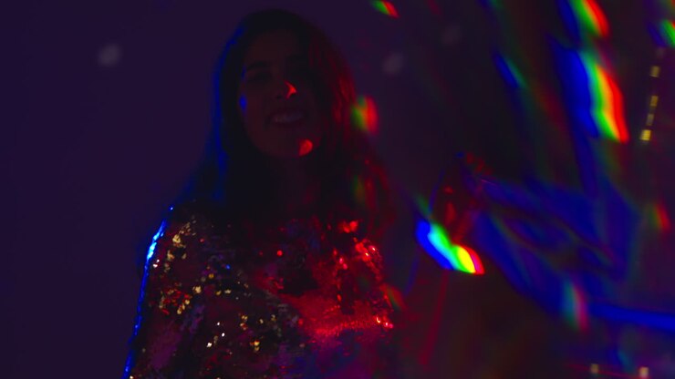Close Up Of Woman Having Fun Dancing In Disco Nightclub Or Bar Shot With Tinsel in Foreground 1