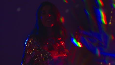 primer plano de una mujer divirtiéndose bailando en un club nocturno de discoteca o bar disparado con oropel en primer plano 1
