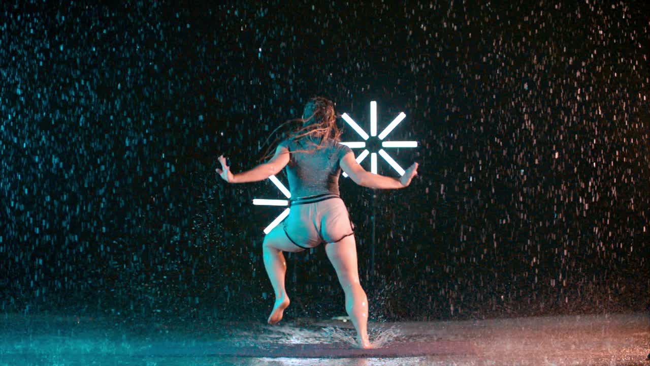Young female dancer performing in the rain, modern dance