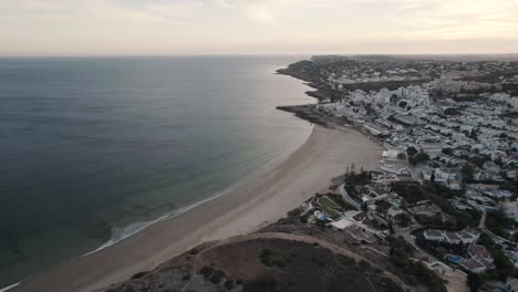 Small-ocean-waves-gently-unfolding-on-sand-beach,-Praia-da-Luz,-Algarve