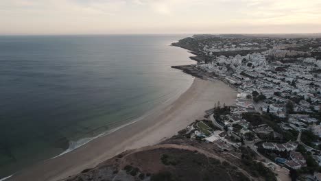 pequeñas olas del océano desplegándose suavemente en la playa de arena, praia da luz, algarve