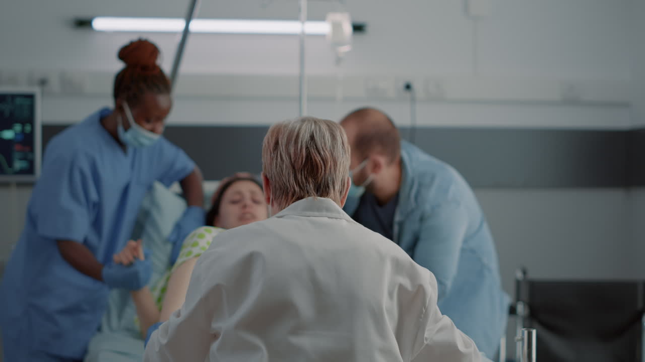 Medico e infermiera afroamericana che aiutano la donna incinta