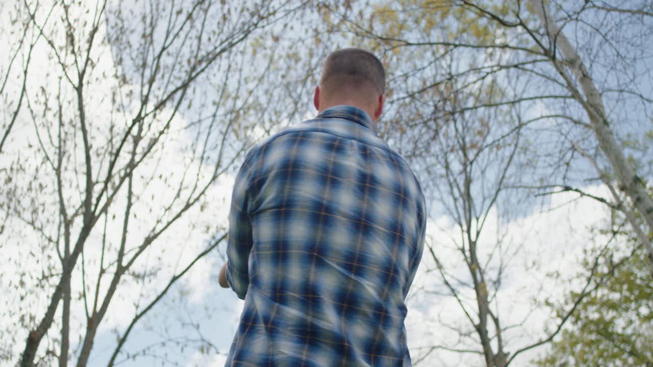 행복한 아버지와 아들이 뒷마당 정원에서 함께 놀고 있습니다. 행복한 작은 소년은 아빠와 함께 재미를 느끼고 있습니다. 아이를 잡고 놀면서 아이를 흔들고 있습니다. 어린 시절의 자유를 즐기며 야외에서 4k