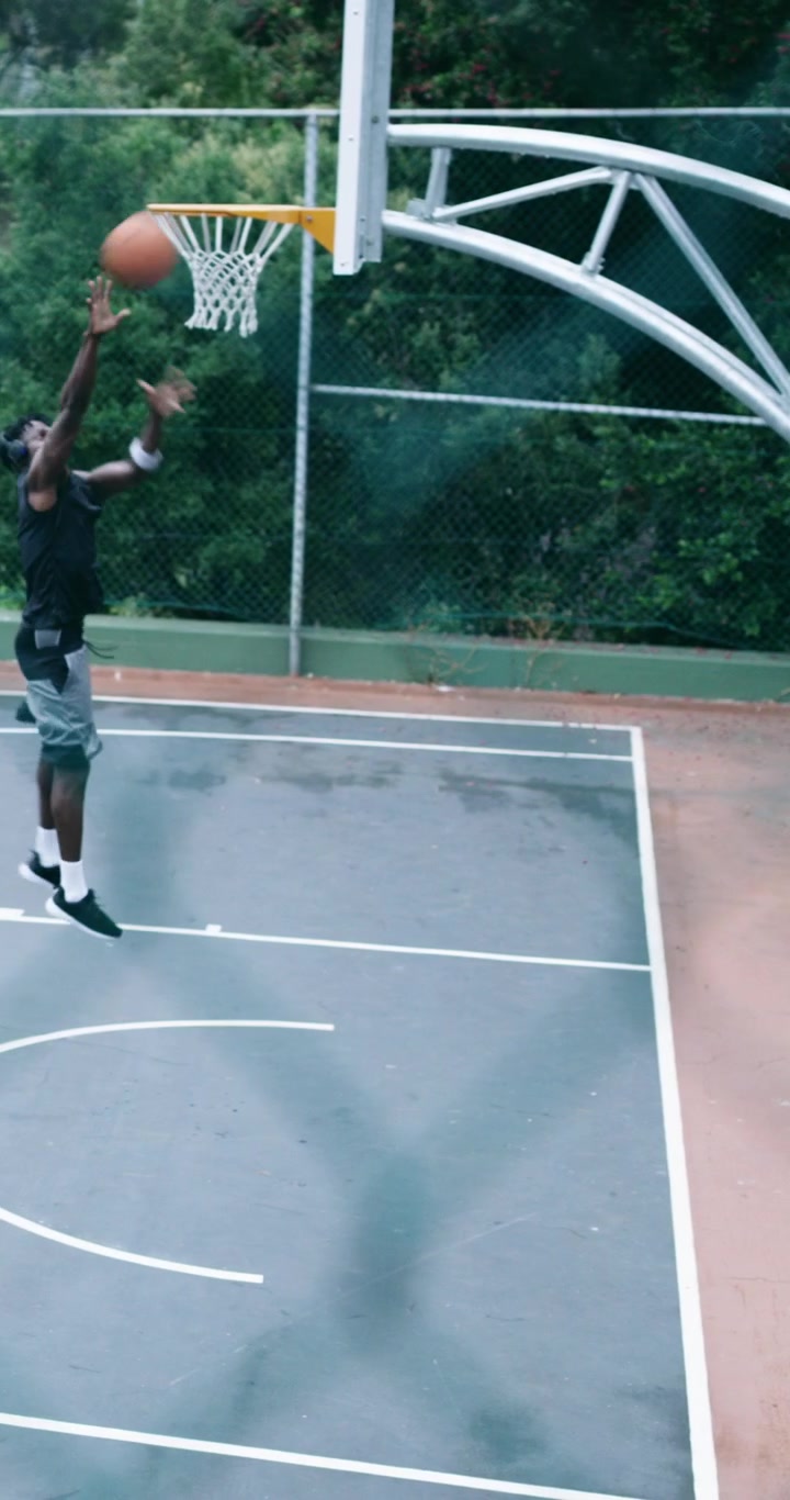 Due uomini che giocano a basket su un campo all'aperto