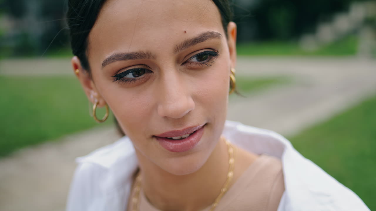 chica sonriente hablando en el parque vertical de cerca. mujer morena contando una historia