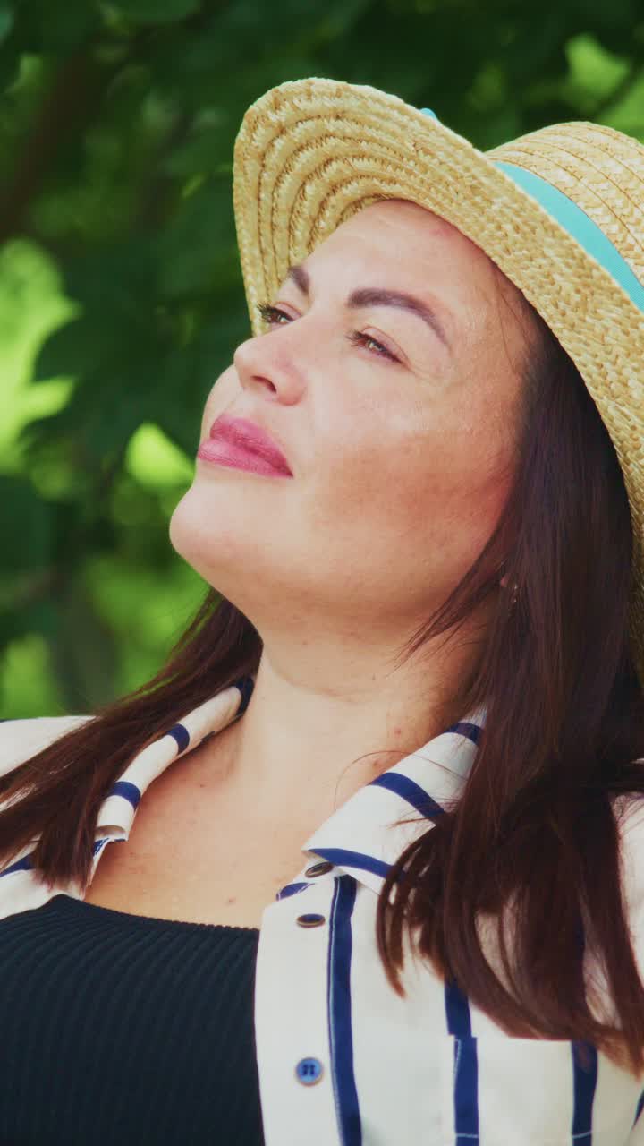 A Relaxed Woman in a Stylish Straw Hat Enjoying Time Outdoors While Engaging with Her Laptop, Capturing the Essence of Leisure and Technology in Harmony