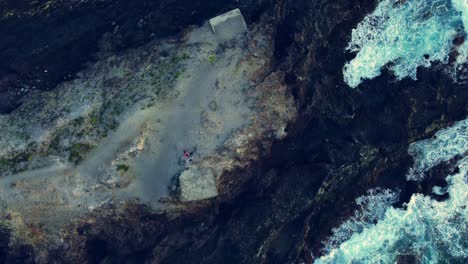 tierra rocosa aislada rodeada de agua azul del océano en los cristianos, tenerife