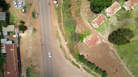 Aerial-view-of-cars-and-people-at-a-Open-Air-Market,-in-Africa---reverse,-drone-shot