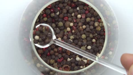 glass spoon black peppercorns