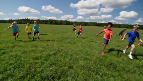 children running and playing in a grassy field
