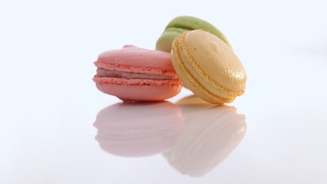 macaroons rotate on white background. three cookies macaroons are stacked on top of each other. traditional french multicolored macaroon. food concept