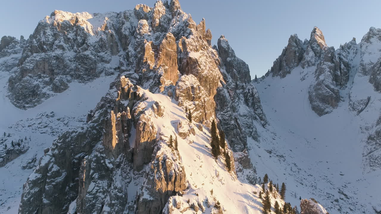 la vista aérea de la cumbre de la montaña tre cime nevada y brillante revela un amanecer dorado sobre una cresta montañosa