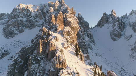 la vista aérea de la cumbre de la montaña tre cime nevada y brillante revela un amanecer dorado sobre una cresta montañosa