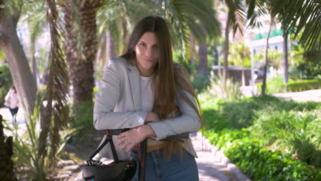 mujer joven con scooter eléctrico en la ciudad mirando y sonriendo a la cámara