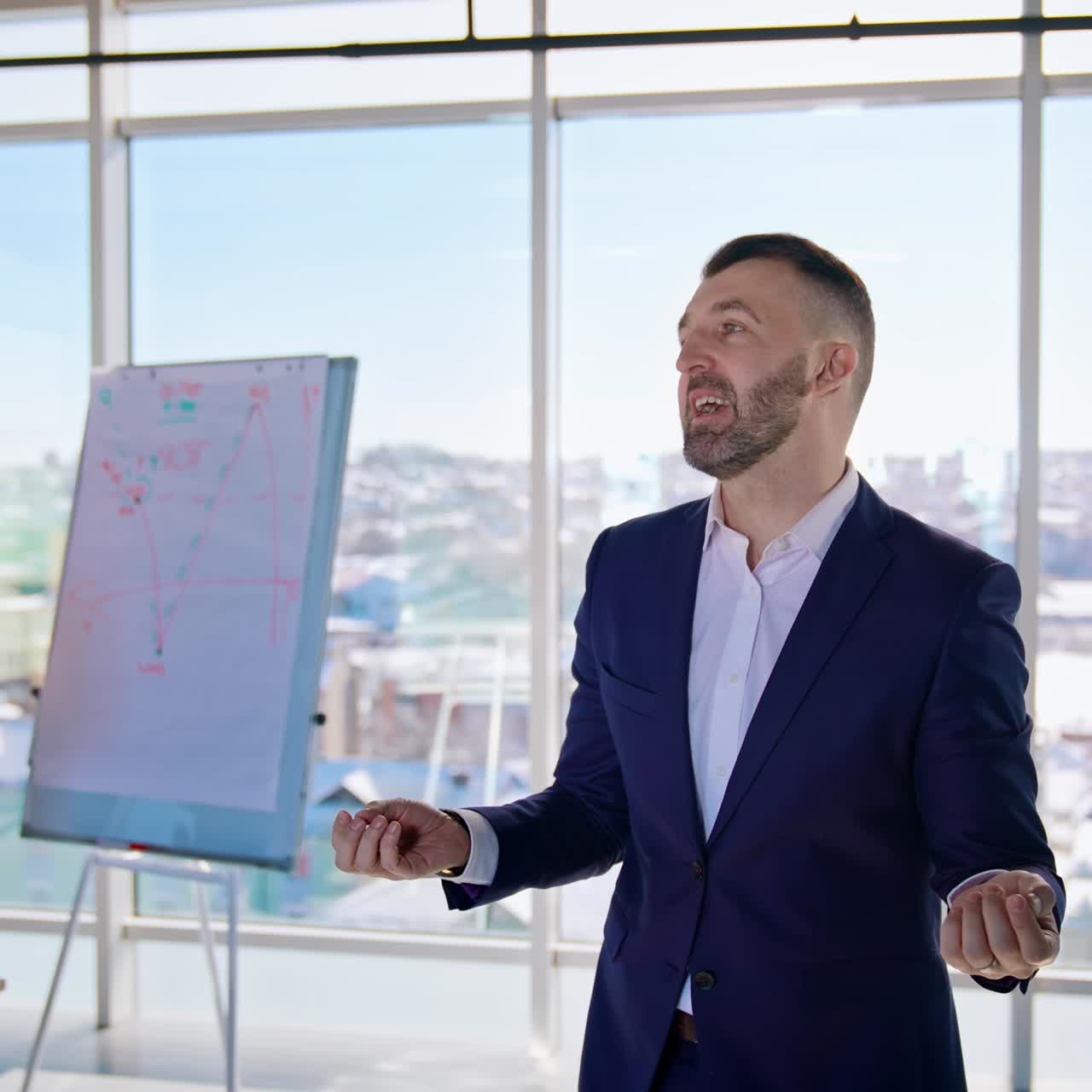 Confident businessman speaking in modern office. Elegant man in costume telling about his success in business on camera. Executive business workers indoors