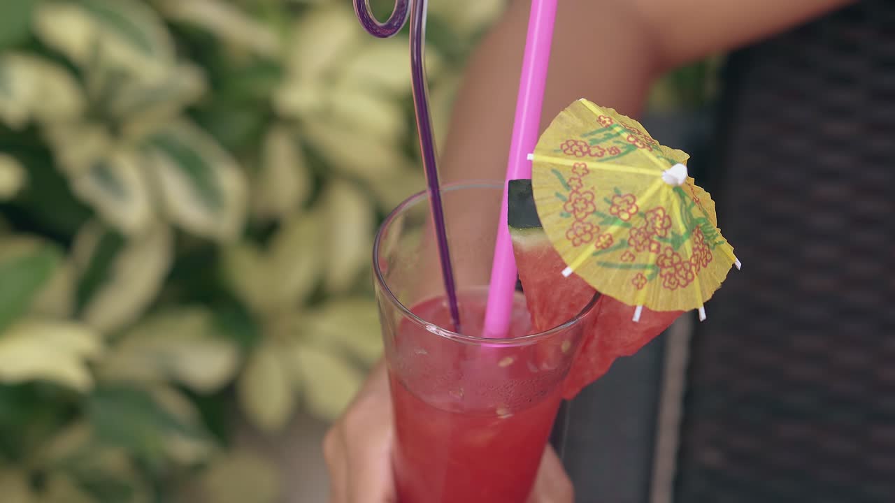 mujer sostiene una bebida en la mano en el reposabrazos de la silla de estar