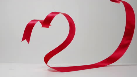 red ribbon heart on white background