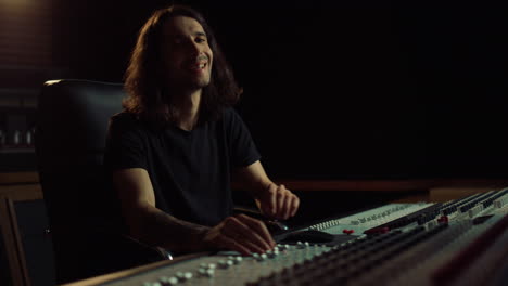 happy man looking to camera in sound recording studio. smiling musician working.