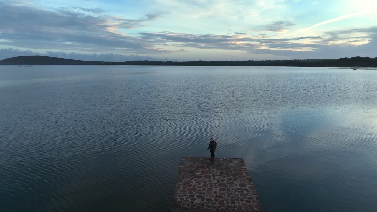 persona de pie en el borde del muelle cuando sube la marea