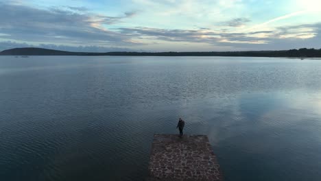 person standing on pier edge as the tide rises