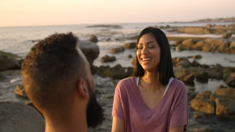 Happy-mixed-race-couple-having-fun-at-beach-during-sunset-4k