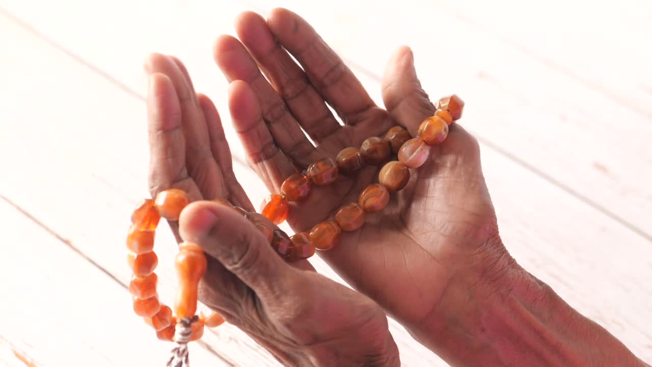 manos de oración con cuentas de oración