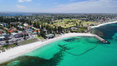 drone view of cottesloe beach and golf course with city skyline in the background