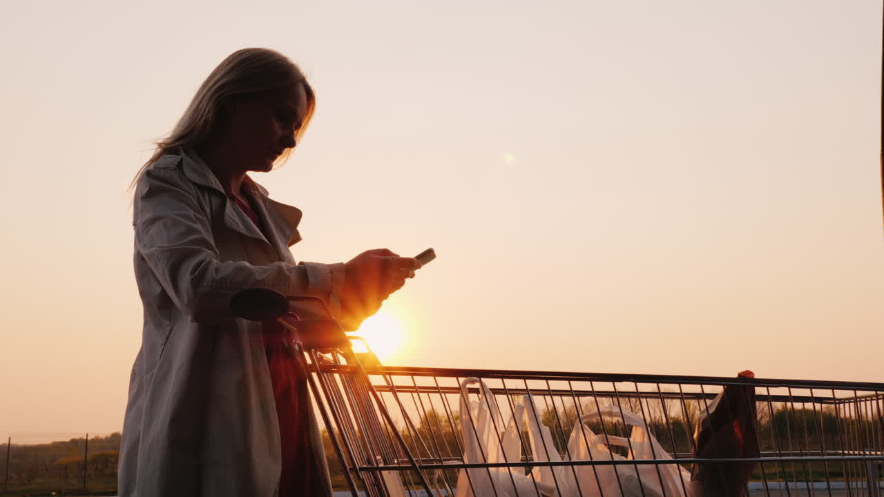 la mujer revisa sus compras en el carro con una lista en el teléfono inteligente