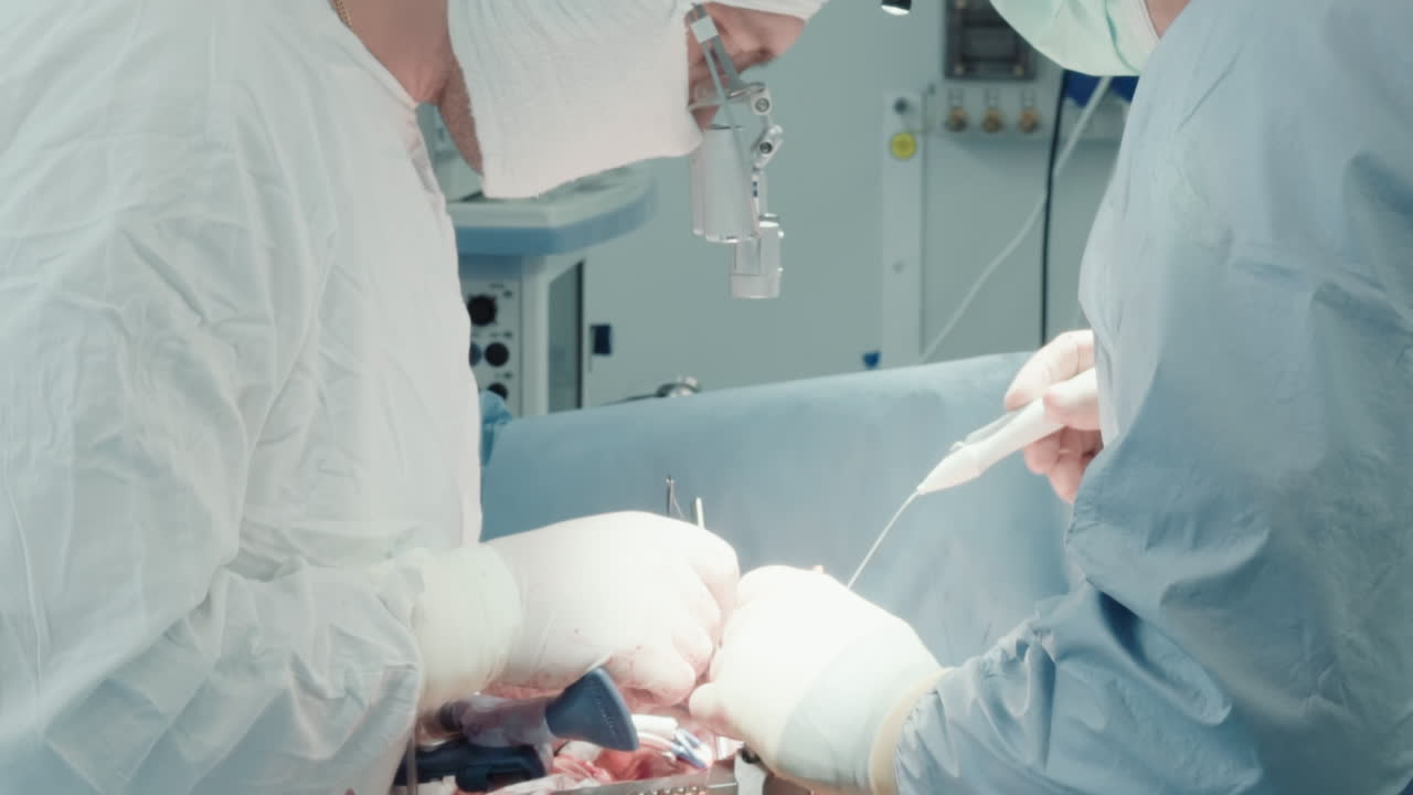 외과 의사는 심장에 수술을 수행합니다. 숙련 된 의료진은 수확 된 이식물을 수술실에서 관상 동맥 질환을 치료하는 혈액 공급에 투입합니다.