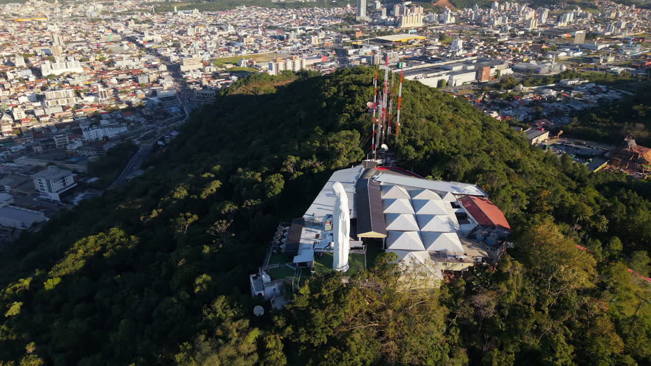 Panoramic aerial fly around the iconic and famous Cristo Luz monumental statue of Jesus Christ, Balneário Camboriú, Santa Catarina, Brazil