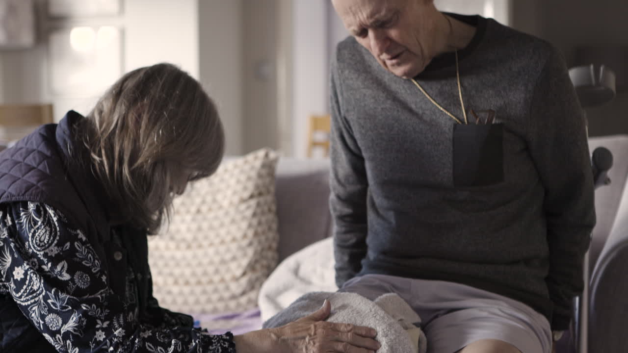 Elderly couple managing knee injury with care and support