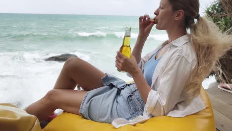 woman relaxing on the beach with a beer