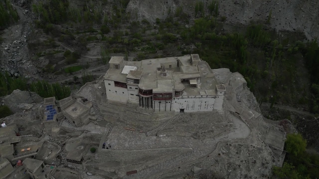 Voo de drone em baixa altitude sobre a histórica Fortaleza de Baltit no Vale de Hunza, Karimabad, Paquistão, com arquitetura tradicional de pedra e vistas para a montanha
