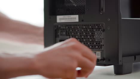 hombre conectando una fuente de alimentación a un caso de computadora