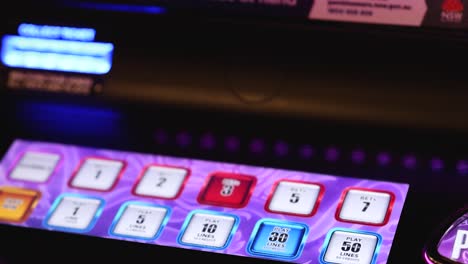 hand pressing buttons on a colorful slot machine