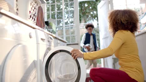 happy african american mother and son doing laundry together, slow motion