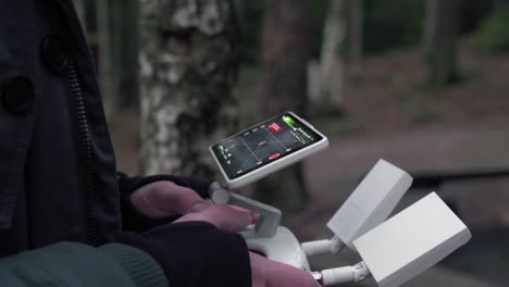 professional drone pilot operating his drone with his white remote for inspection or filmmaking