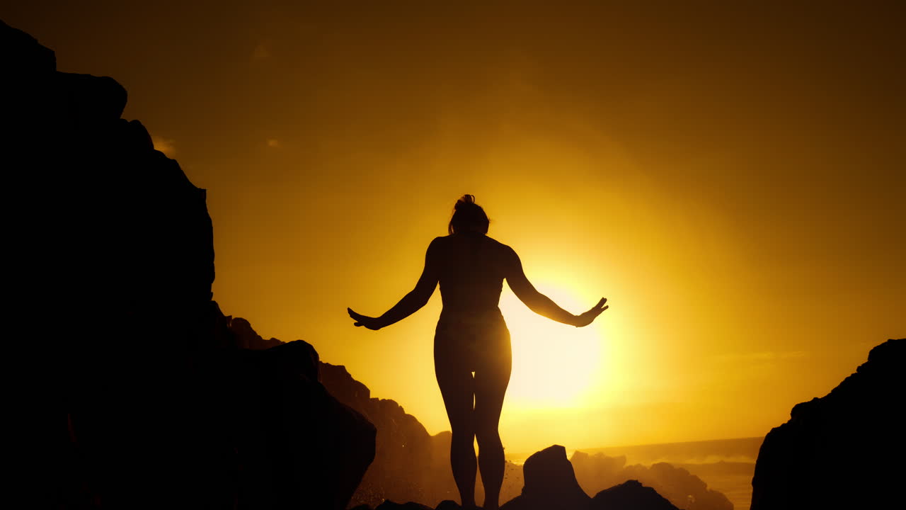 Woman Silhouetted at Sunset on Rocks