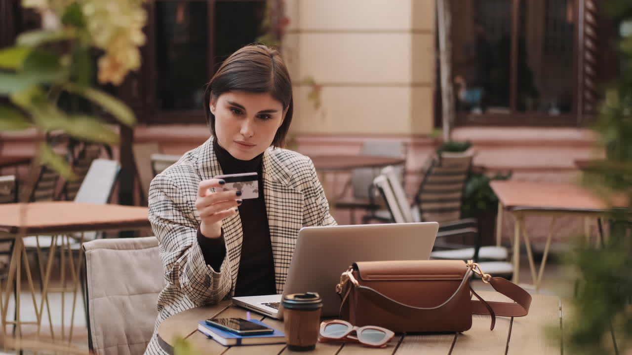 красивая улыбающаяся женщина платит за покупки в интернете кредитной картой.