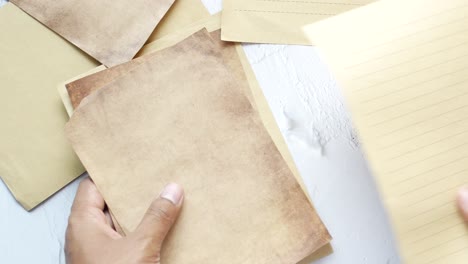 hands holding aged paper and notebook