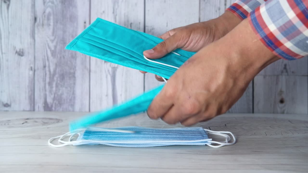 persona que sostiene y exhibe máscaras faciales