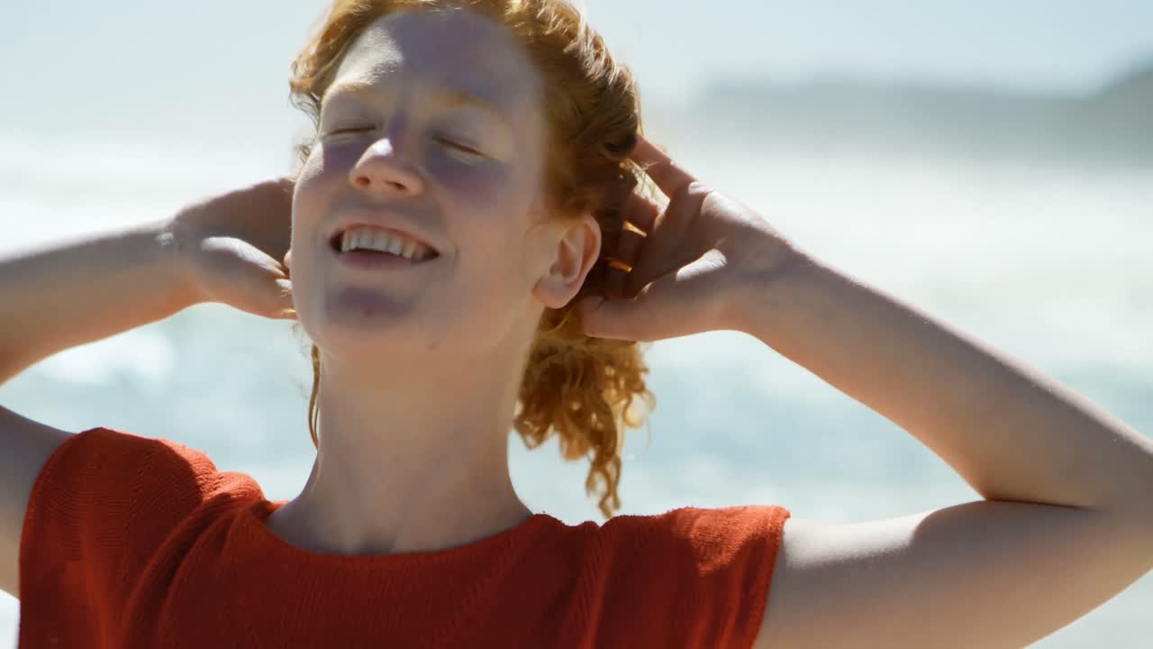 mujer feliz de pie en la playa 4k