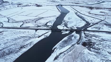 Fluss-Mit-Brücke-In-Der-Nähe-Von-Schneebedeckten-Bergen