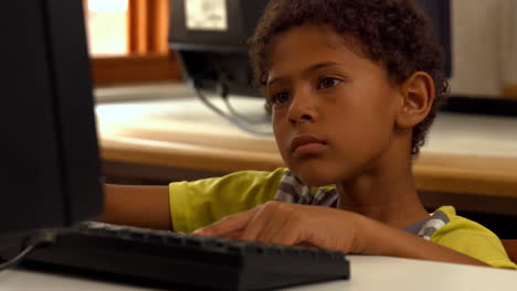 alumno lindo usando la computadora en la escuela