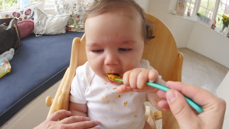 point of view shot of baby being fed in high chair