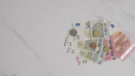 Overhead-Währungsaufnahme-Von-Euro-Banknoten-Und--Münzen,-Die-Auf-Marmoroberfläche-1-Gezählt-Werden