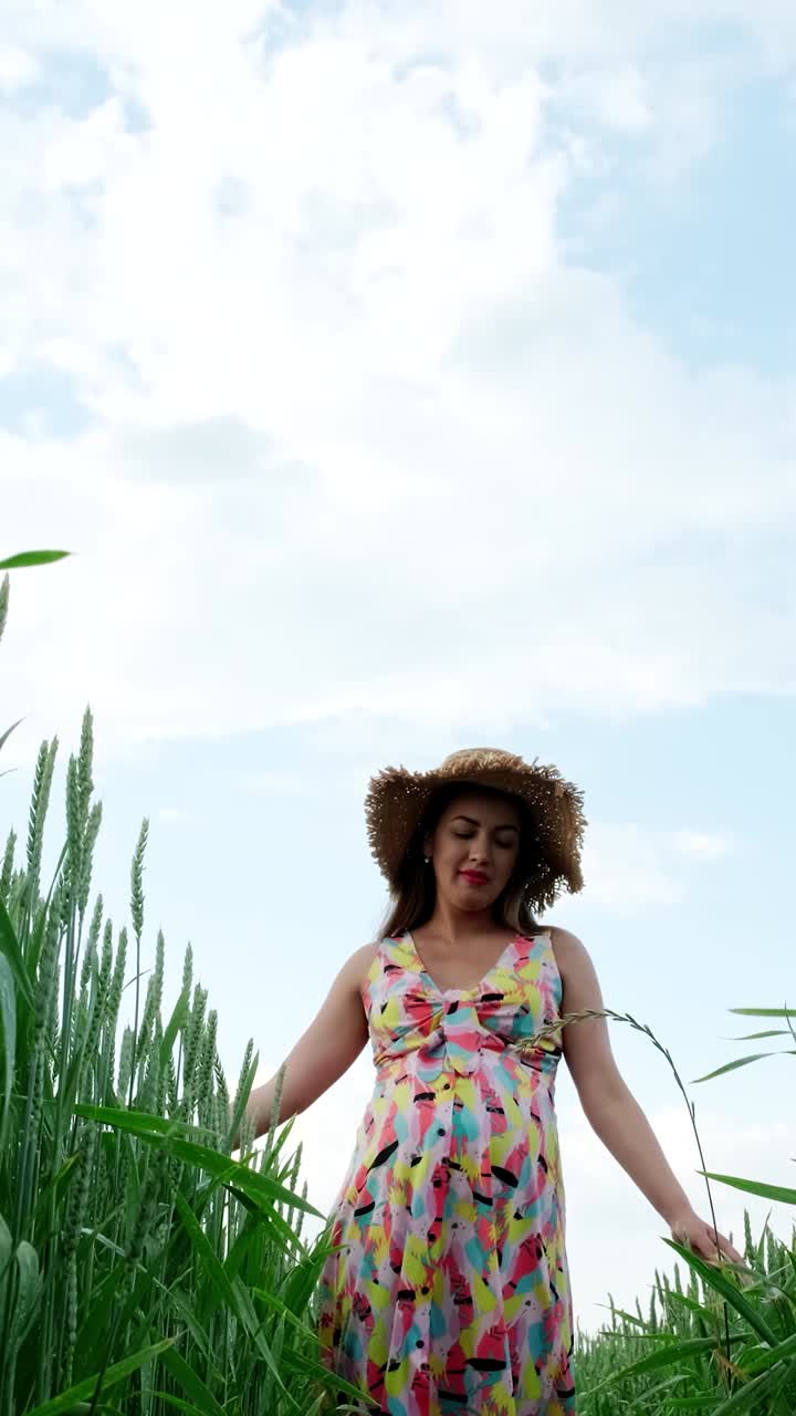 Woman in a Colorful Dress and Straw Hat in a Wheat Field
