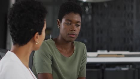 Two-diverse-businesswoman-talking,-working-together-in-office