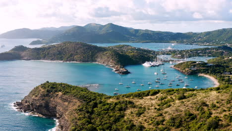 Sonnige-Luftaufnahme-Des-Englischen-Hafens-In-Antigua,-Karibik-Mit-Blick-Auf-Yachten,-Segelboote,-Marina,-Bucht-Und-Klippen